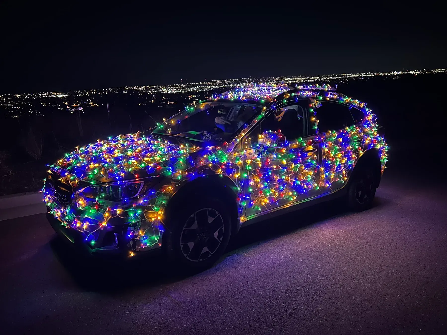 Carson’s car covered in Christmas lights at night